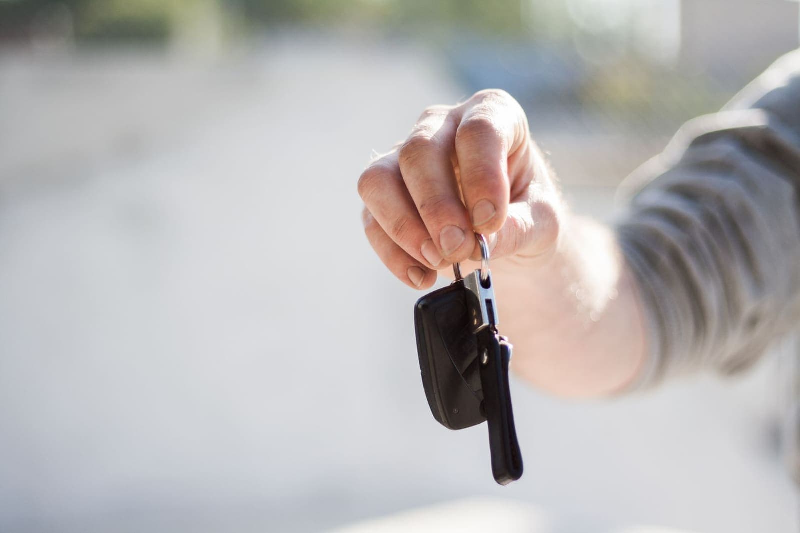 Een hand houdt een autosleutel met afstandsbediening omhoog
