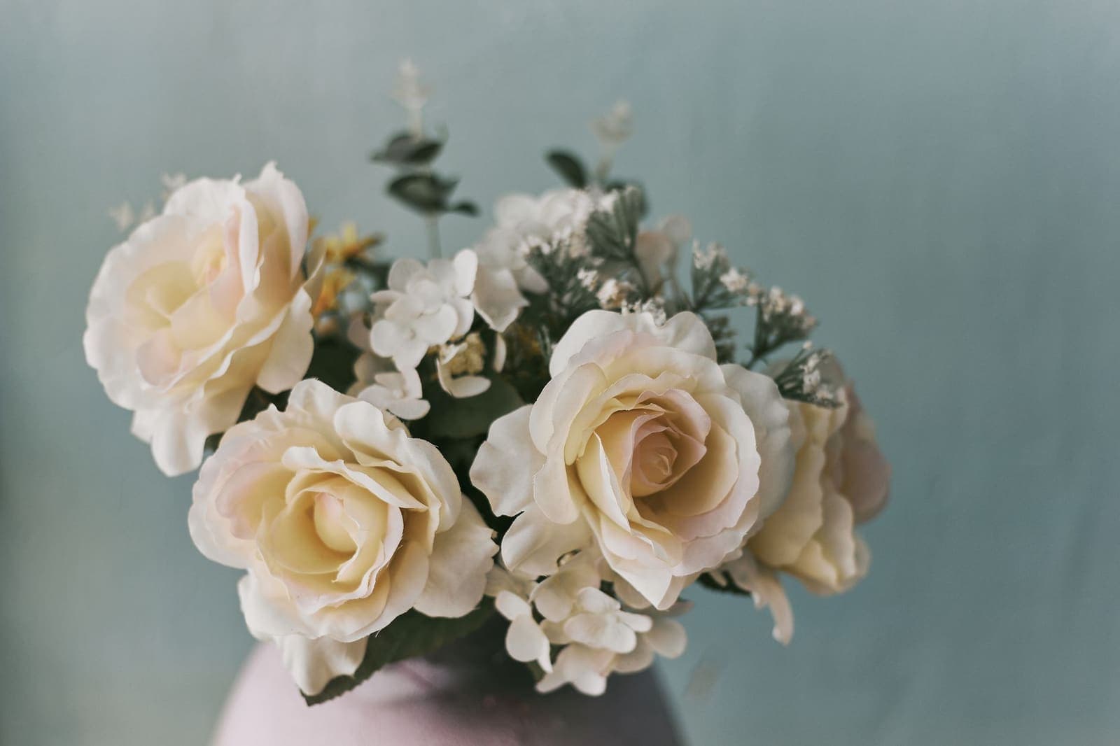 Een boeket witte rozen tegen een rustige, zachtblauwe achtergrond